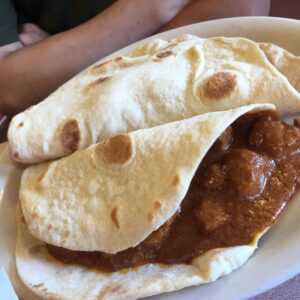 2 Carne Guisada tacos on flour tortillas on platter