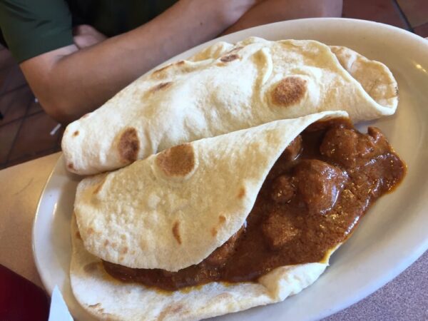 2 Carne Guisada tacos on flour tortillas on platter