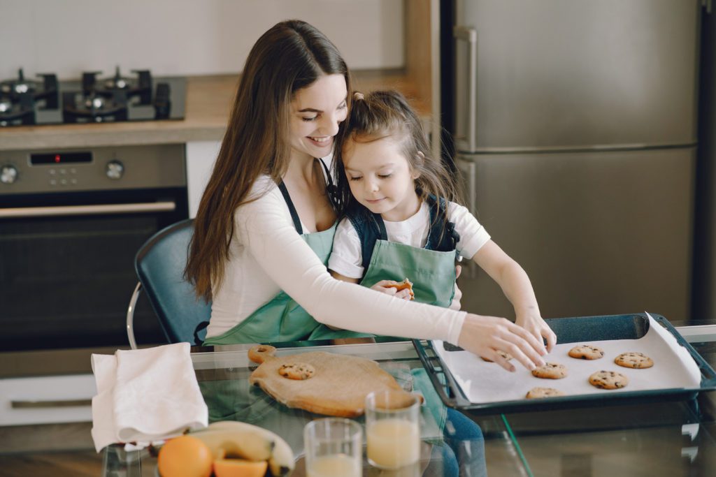 woman and child bake cookies