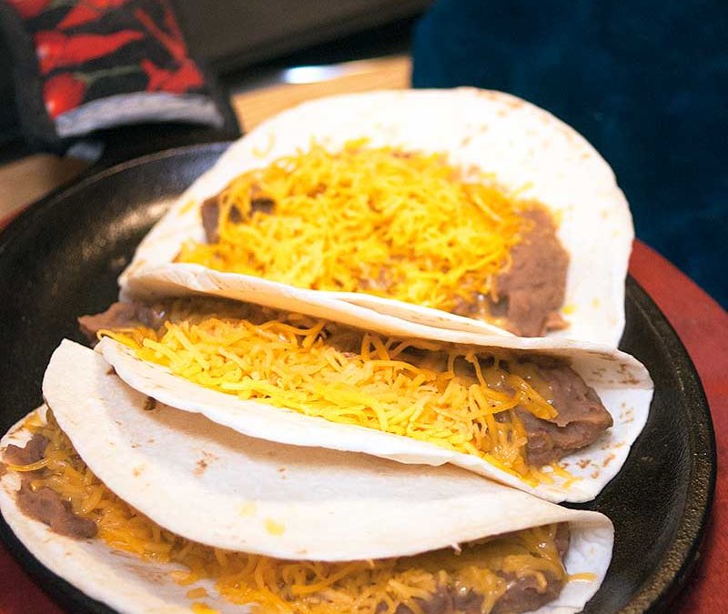 flour tortilla bean and cheese tacos on plate