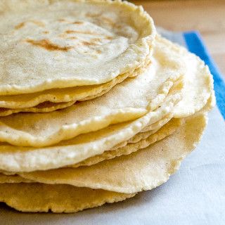 fresh stack of corn tortillas on kitchen towel