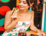woman eats crispy taco in tex-mex restaurant